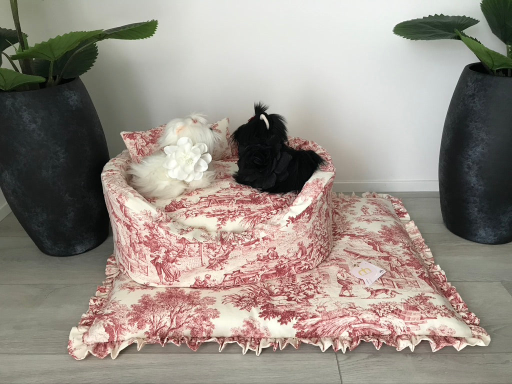 cuccia sofà e materassino con rouche coordinato in tessuto toile de jouy burgundy appoggiati su pavimento.