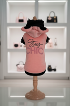 Felpina rosa pesca per cane Stay Chic con cappuccio con orecchie con scritta in strass e glitter bordi neri con pizzo esposta su manichino in boutique