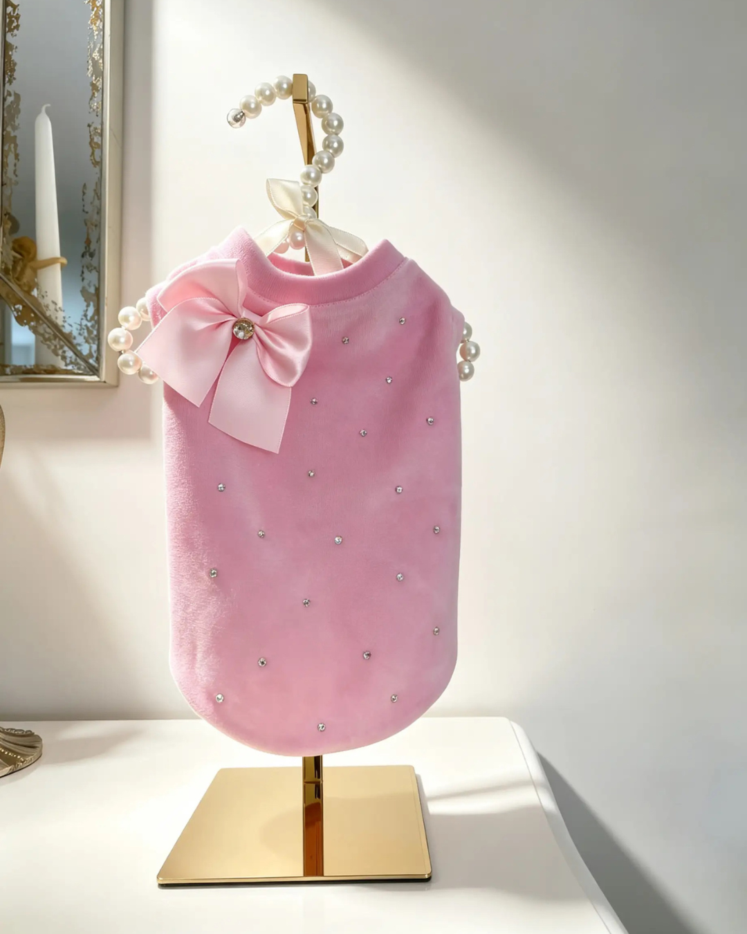 T-shirt rosa barbie per cane con strass e fiocco in satin su manichino dorato appogiato su mobile bianco –  MPI